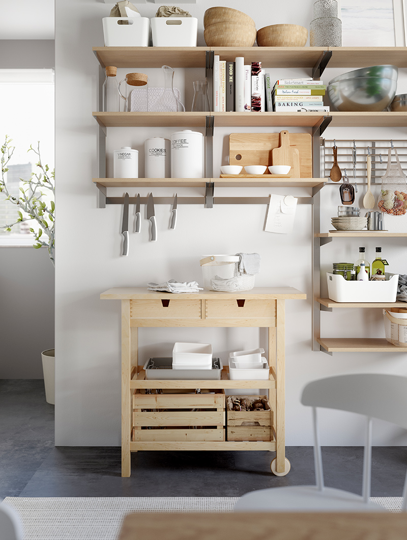 Carro de cocina arrimado en la pared con varios estantes de pared con diversos utensilios, ollas y sartenes