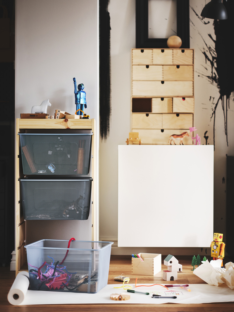 Children's space with wooden furniture, storage baskets, and a desk. A creative ambiance with messy drawings and toys.