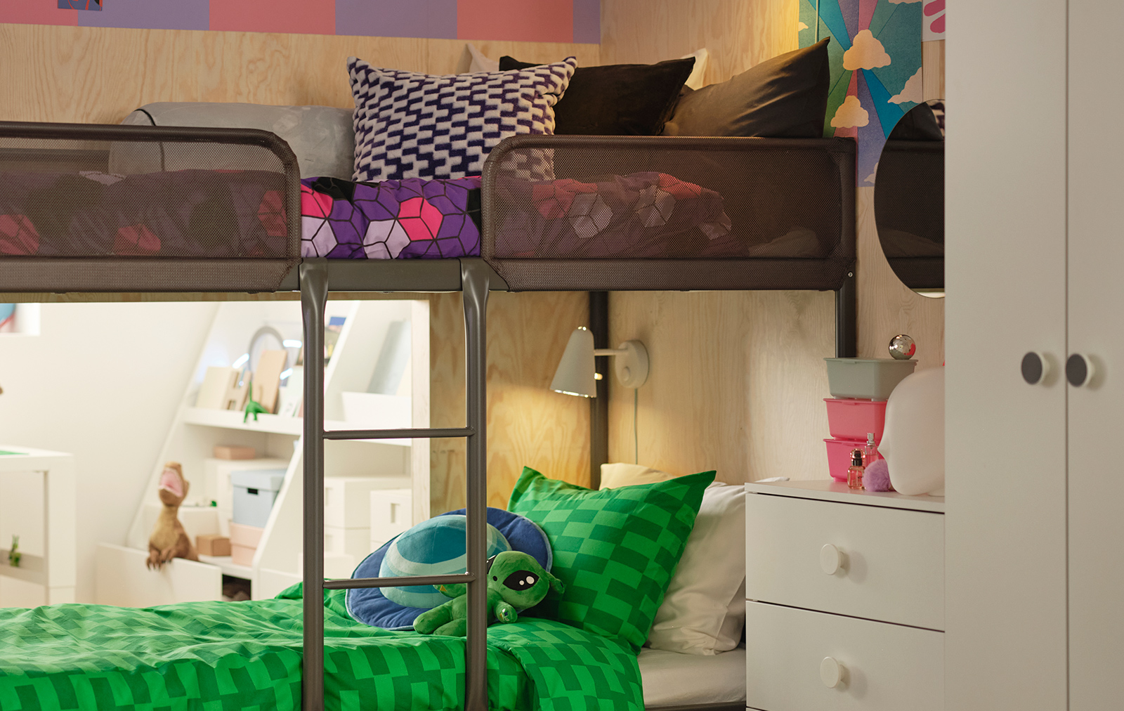 Literas modernas con ropa de cama verde y púrpura, y una pared de madera clara. Un ambiente divertido y juvenil en un dormitorio compartido.