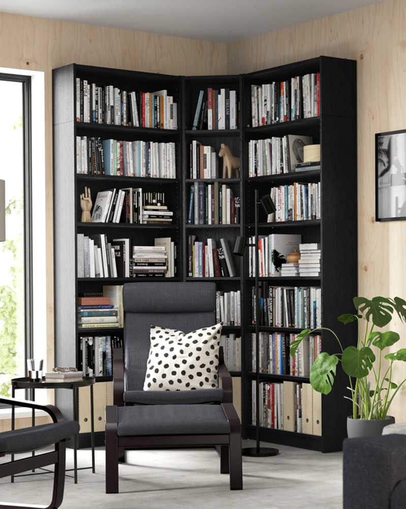  Una librería BILLY color negro junto a un sillón negro POÄNG
