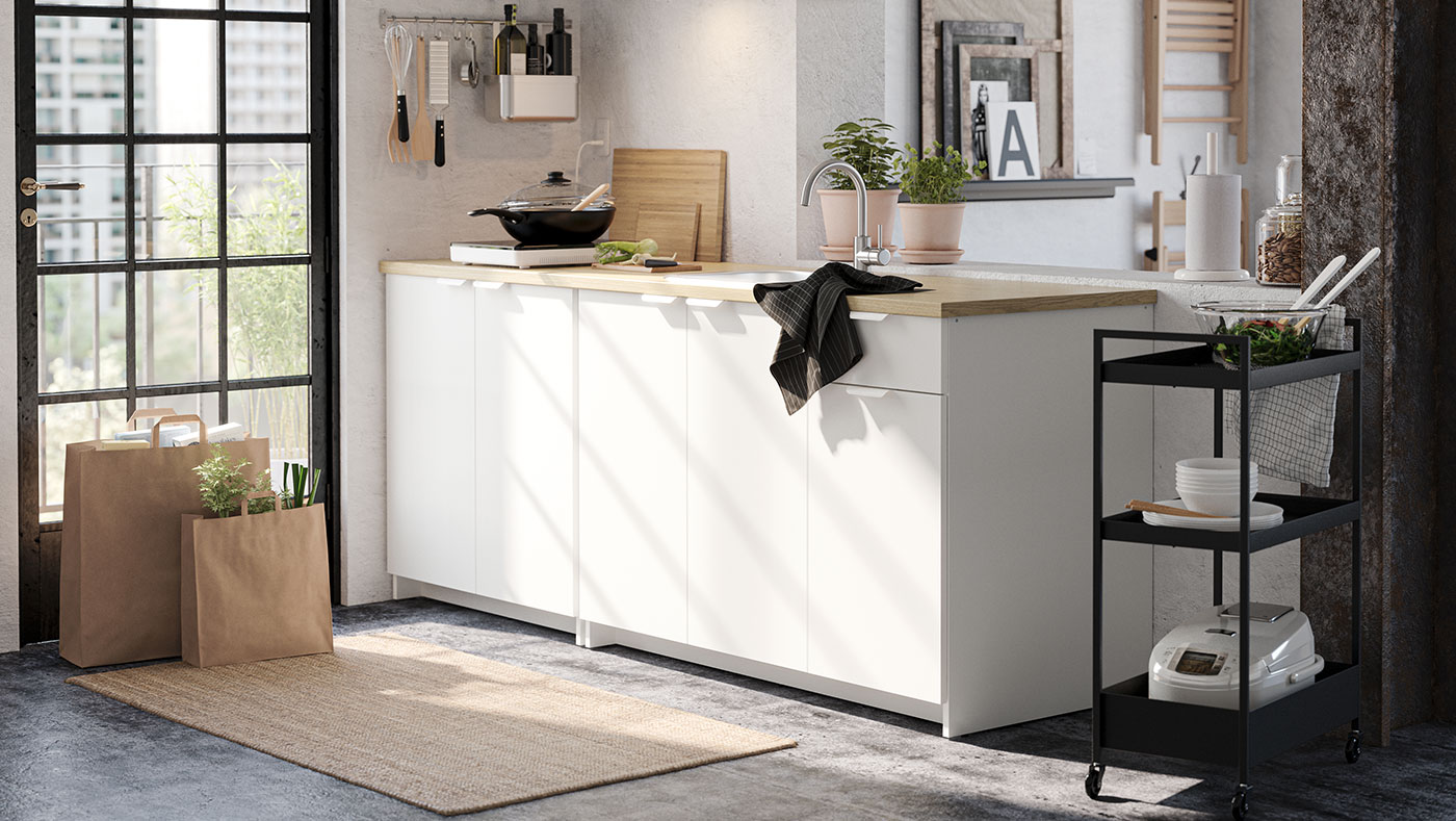 Pequeño mueble de cocina junto con un carrito de cocina de metal negro