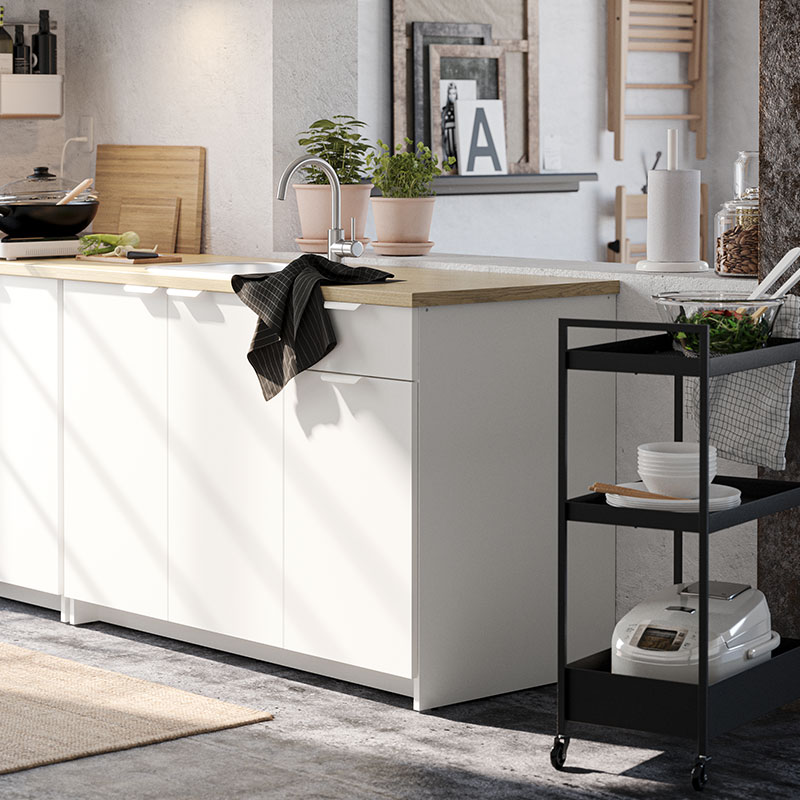 Pequeño mueble de cocina junto con un carrito de cocina de metal negro