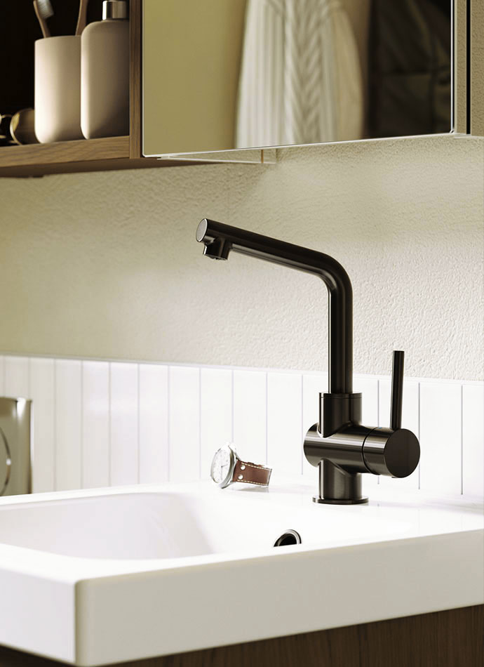 Grifo negro moderno sobre lavabo blanco, fondo de azulejos blancos, ambiente limpio y minimalista.