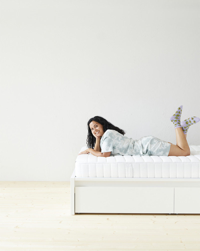 Una mujer acostada sobre una cama de la serie MALM