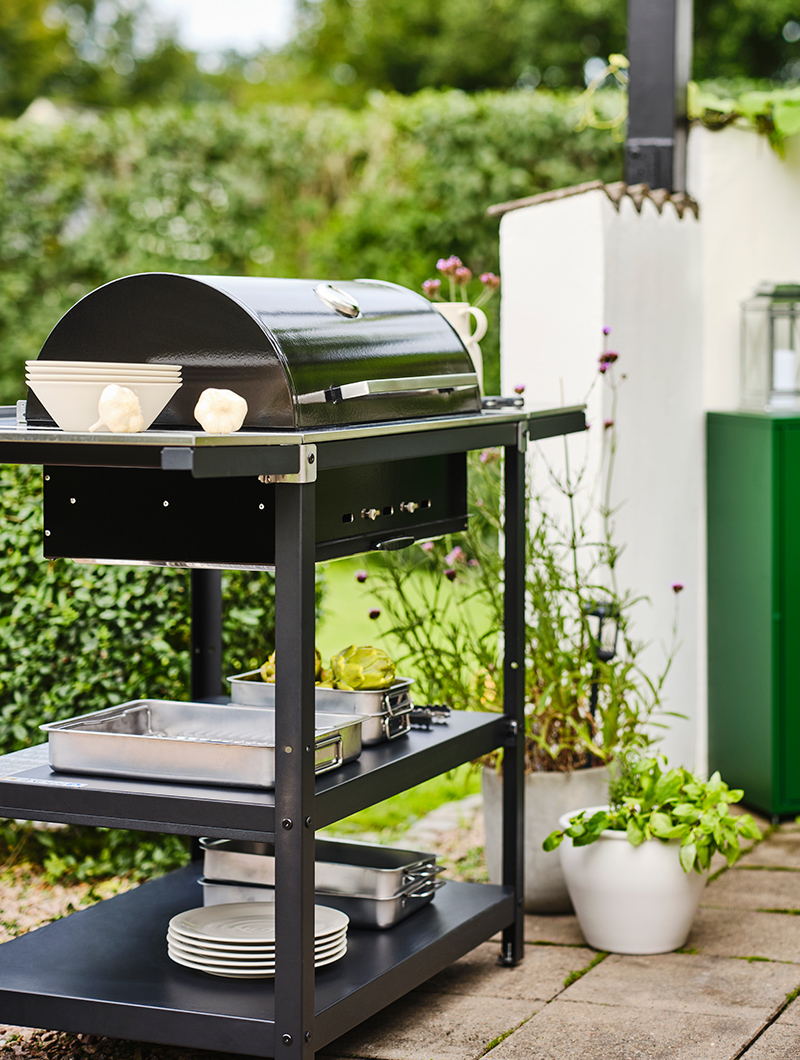 se puede ver una barbacoa negra en un espacio ajardinado.