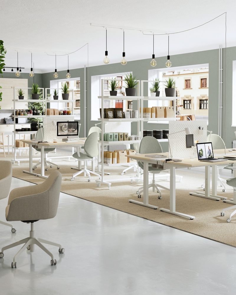 Large view of a modern and creative office with work chairs and desks and shelves, all in very light colors such as whites and grays.