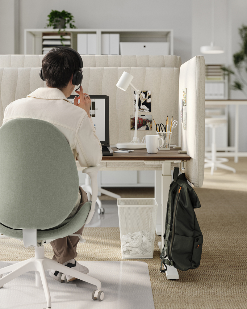 Back view of a person working in an office cubicle, his work chair is visible and he appears to be on a video call.