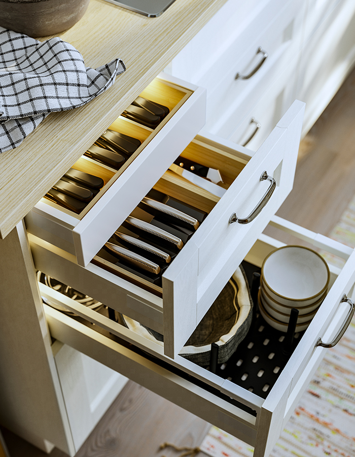 Cajones de cocina MAXIMERA con frentes de cajón ENKÖPING, equipados con organizadores de utensilios y cuchillos UPPDATERA en el interior.