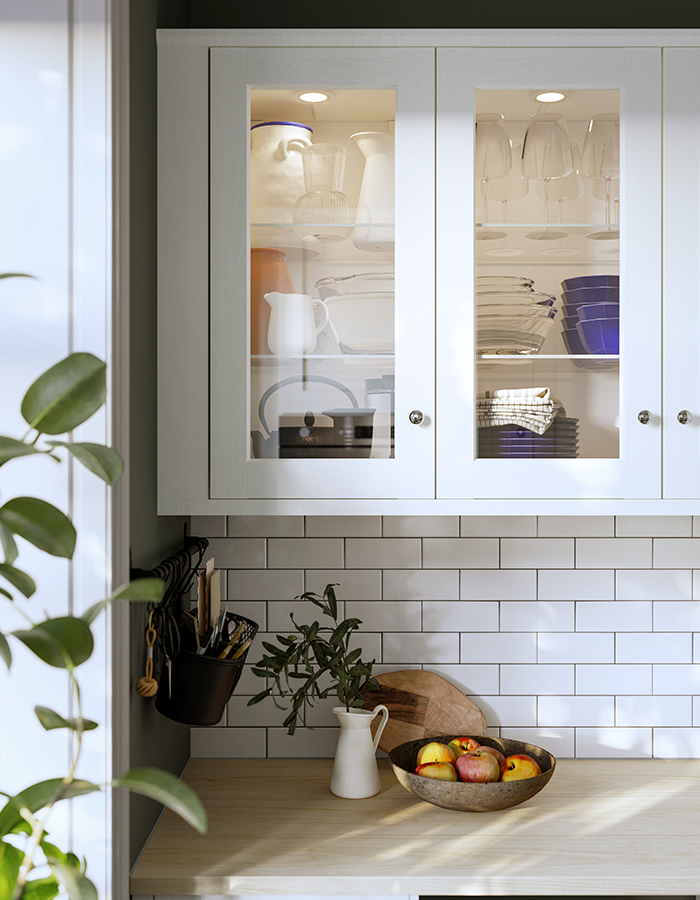 Gabinete de cocina con puerta de vidrio ENKÖPING, tiradores ENERYDA y un riel HULTARP con recipiente.