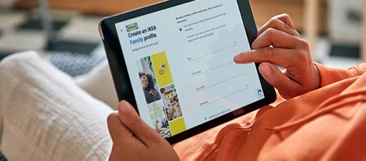 Person relaxing and using a tablet to connect to IKEA’s free Wifi, making shopping easy and comfortable anywhere in the store.