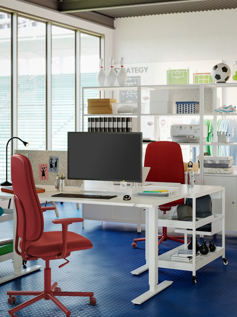 Silla de trabajo roja delante de un escritorio blanco en una oficina en un entorno moderno y creativo.