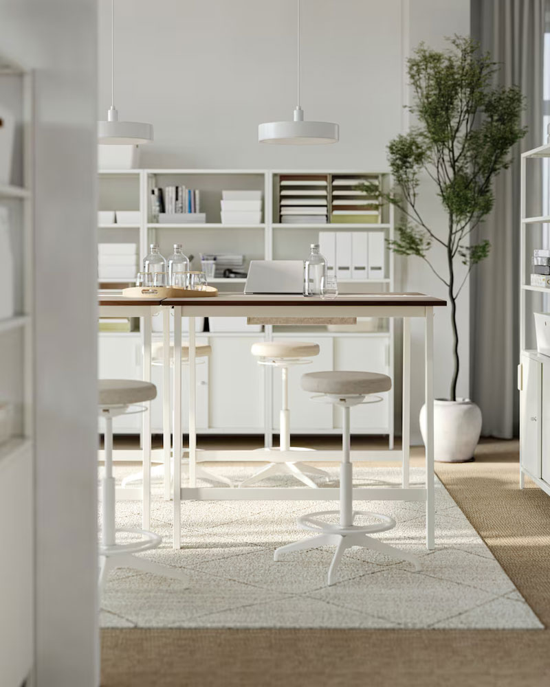 Mesa de reuniones con sillas altas, en un entorno creativo moderno y elegante.