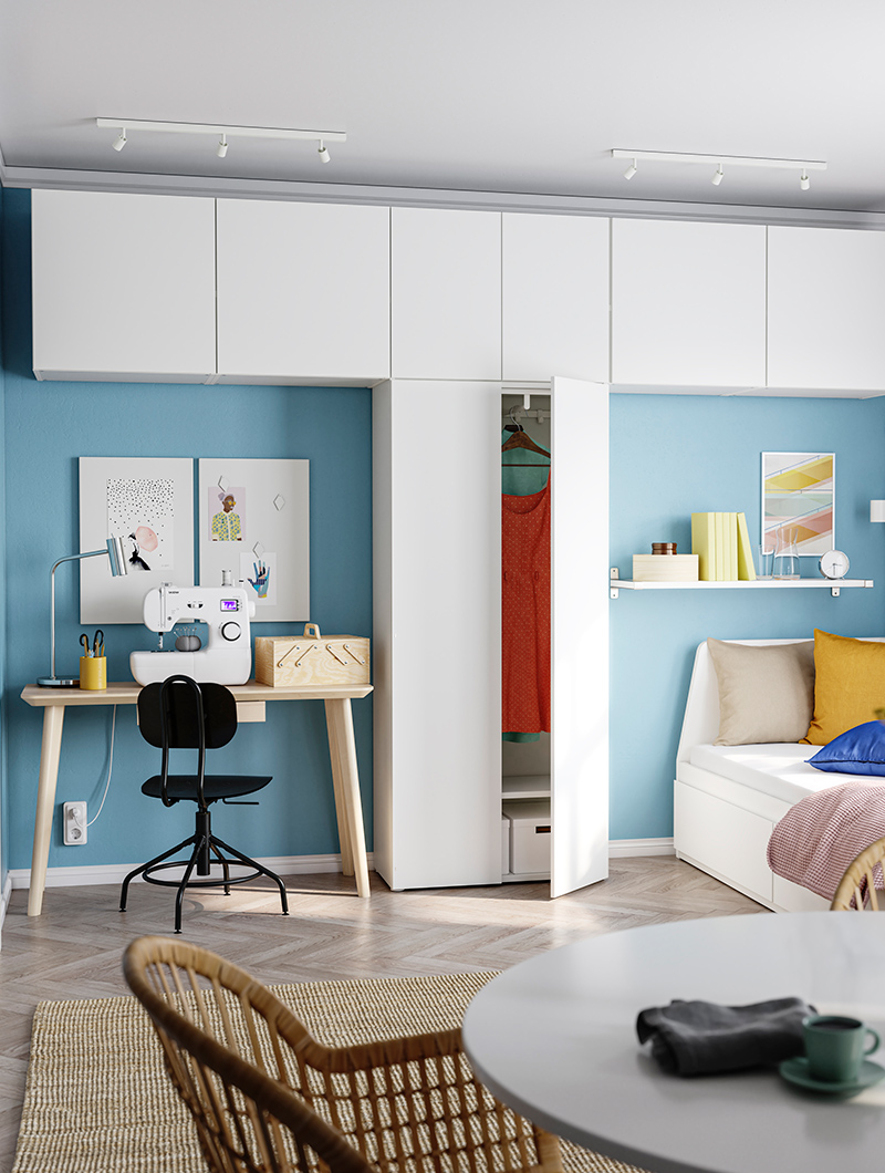A bedroom with a LISABO table and a PLATSA wardrobe with 8 doors on the right, a round DOCKSTA table, and a LOHALS rug.