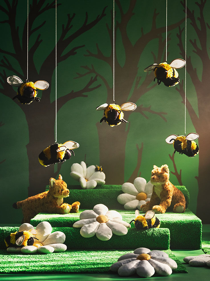 Stuffed bee and daisy flower toys. Enchanted forest atmosphere with magical lights.