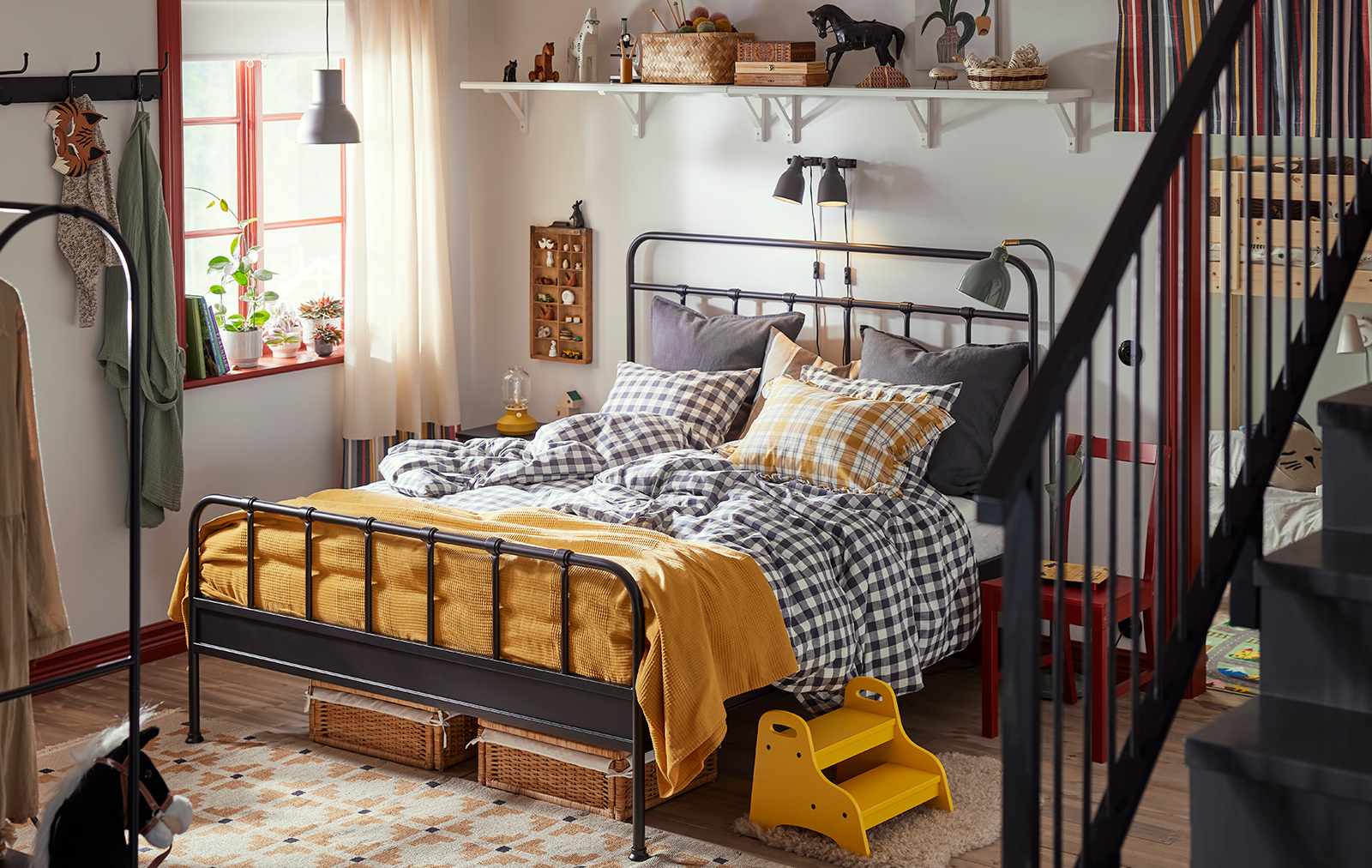 Habitación calida, con cama STJÄRNÖ y edredones de cuadros. 