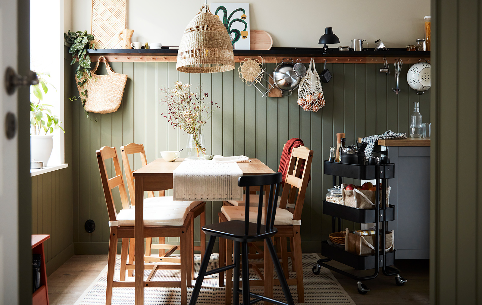Comedor de estilo vintage, mesa y sillas de estilo roble, un gran ventanal, una lámpara colgante tejida, ambiente acogedor y tranquilo.