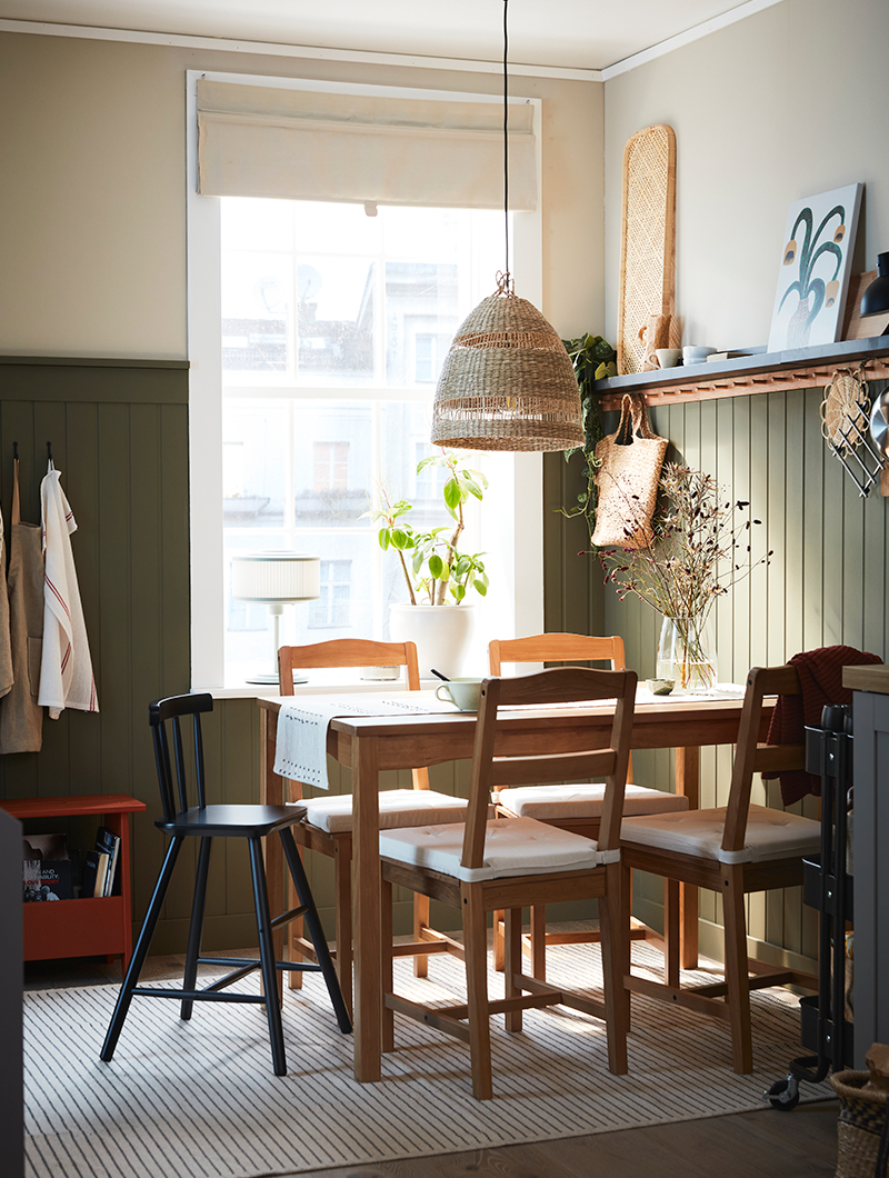 Comedor de estilo vintage, mesa y sillas de estilo roble, un gran ventanal, una lámpara colgante tejida, ambiente acogedor y tranquilo.
