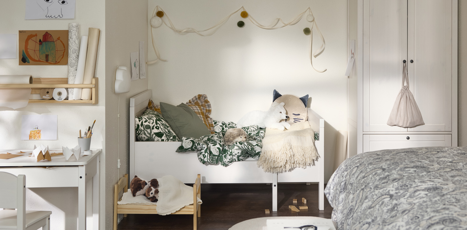 Habitación infantil acogedora con cama blanca, peluches y detalles decorativos en tonos suaves.