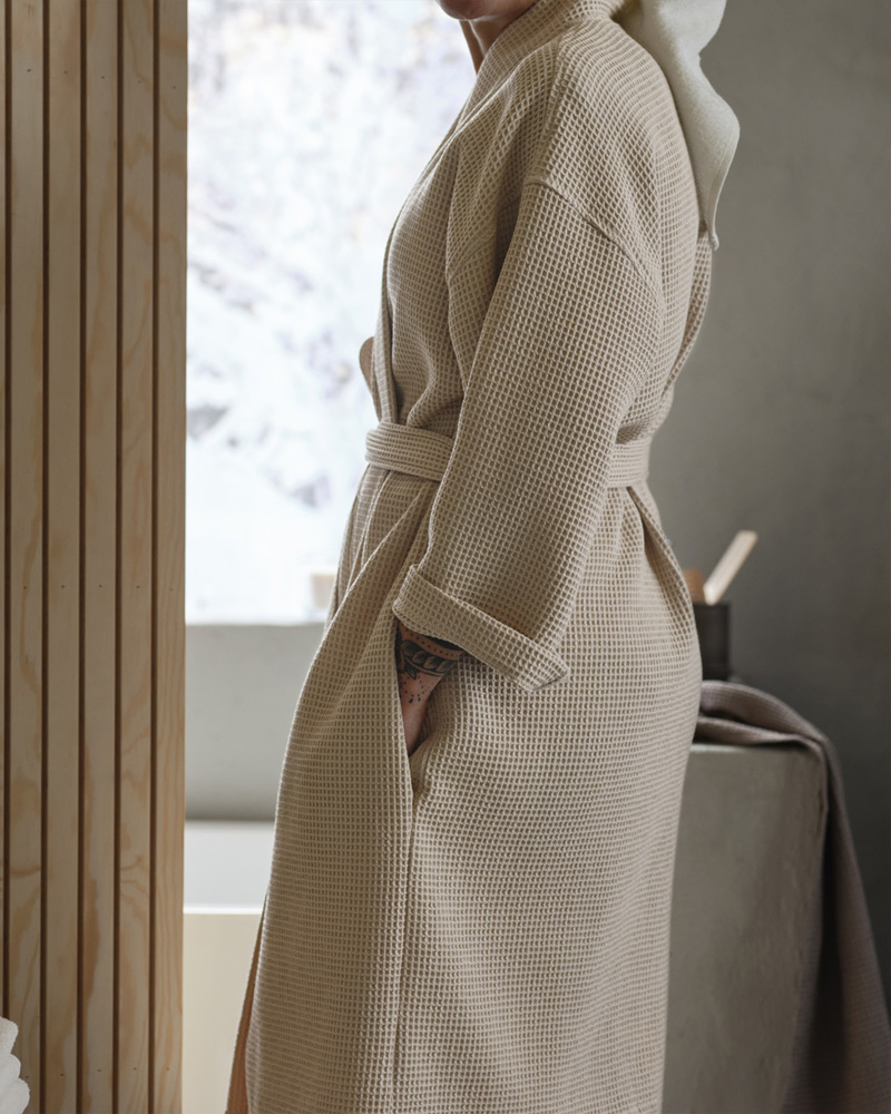 A person wearing a BJÄLVEN bathrobe.