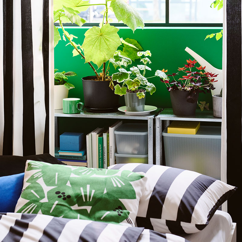  A SLÅNHÖSTMAL duvet set along with an UNDERBLOMMA cushion in a bedroom.