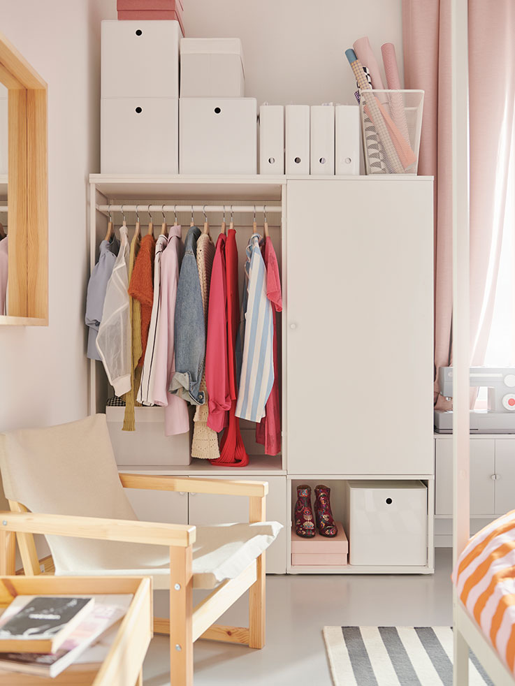SJÄLSÖ armchair in front of a PLATSA wardrobe with a KUGGIS storage box in a bedroom.