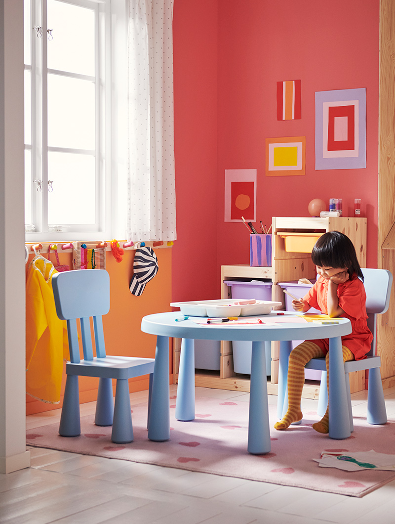  A girl sitting and drawing on a MAMMUT table and chair set.