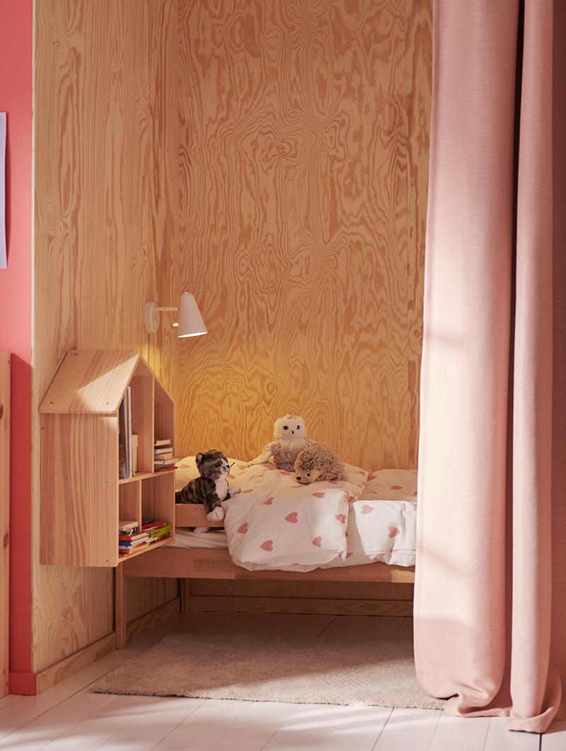  FLISAT dollhouse next to a BARNDRÖM duvet in a children's room.
