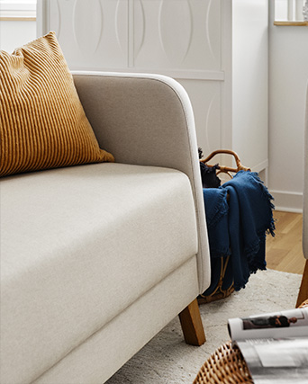 A living room with a two-seat LINANÄS sofa and a cushion on top.