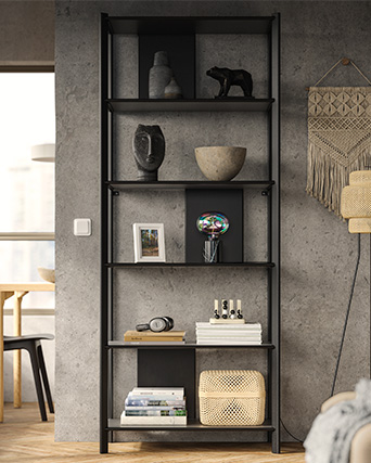 Black shelving unit with decorative items against an industrial-style grey wall.