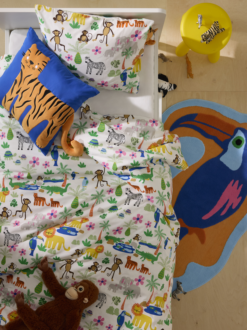 Bed with duvet in bright colors and a soft toy, offering a cozy and fun space to rest. 