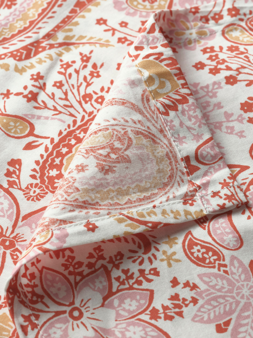 Close-up of a sheet with a detailed floral and colorful pattern.