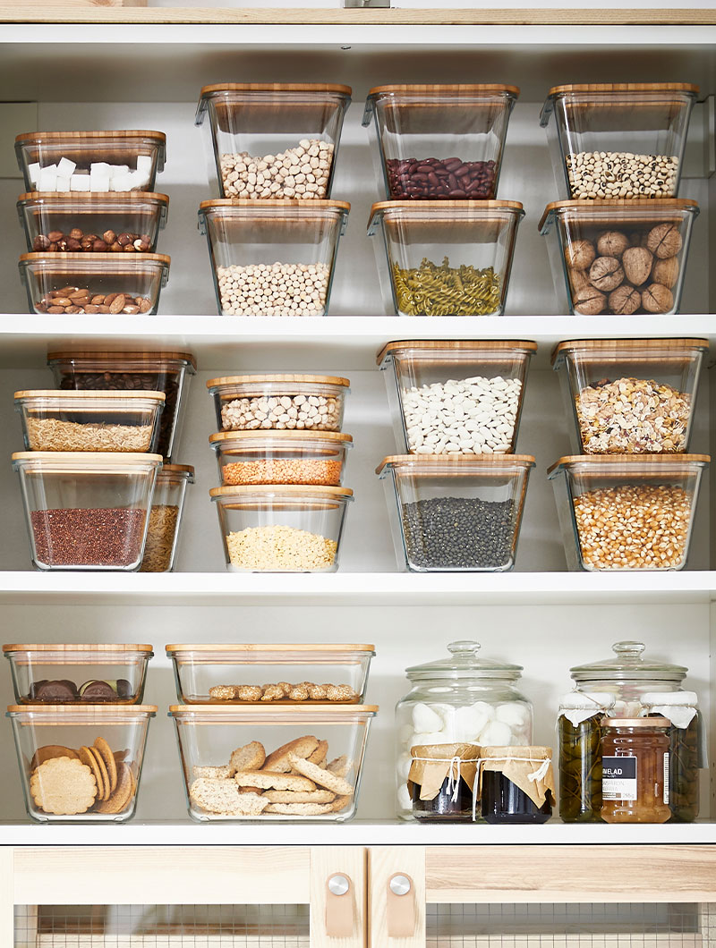 Varios recipientes para alimentos IKEA 365+ sobre un gabinete de cocina.
