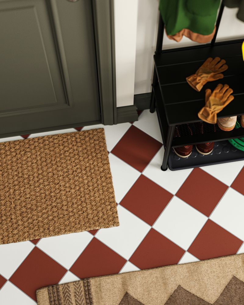 Close-up of entryway floor with red and white checkered tiles, a doormat, and a shoe rack.