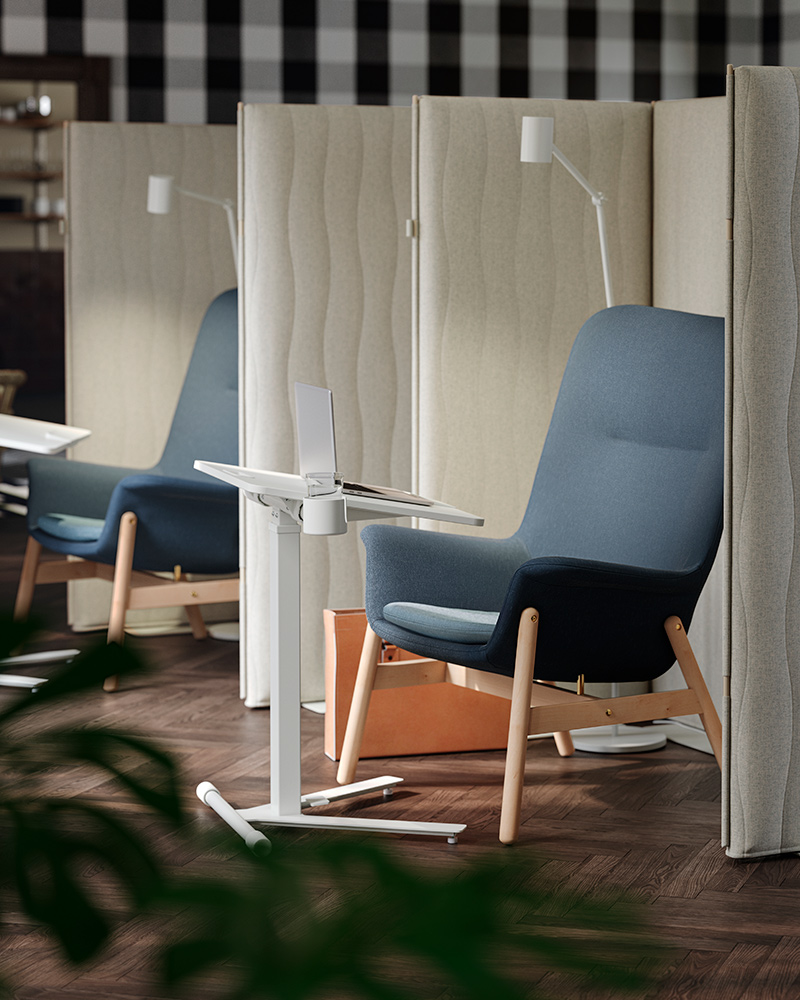 A focus corner with two blue VEDBO armchairs, MITTZON acoustic screens around them, and MITTZON laptop tables in front.