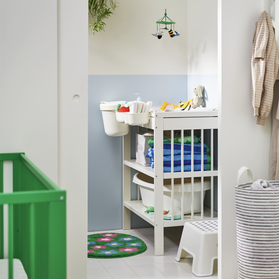 A bright nursery featuring a white GULLIVER changing table, neatly organised with baby essentials and colourful towels.