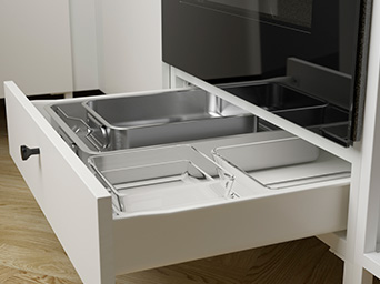 Open white bottom drawer with glass baking dishes and a metal tray.
