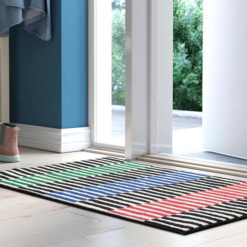 Multicoloured asymmetrical striped doormat in the hallway of a bright house