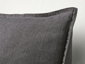Close-up of a dark grey decorative pillow with a stitched edge, showing the fabric texture to add comfort and style.