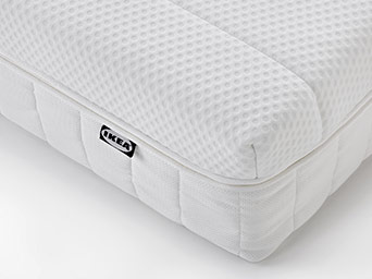 Close-up of a clean white mattress with an IKEA label.