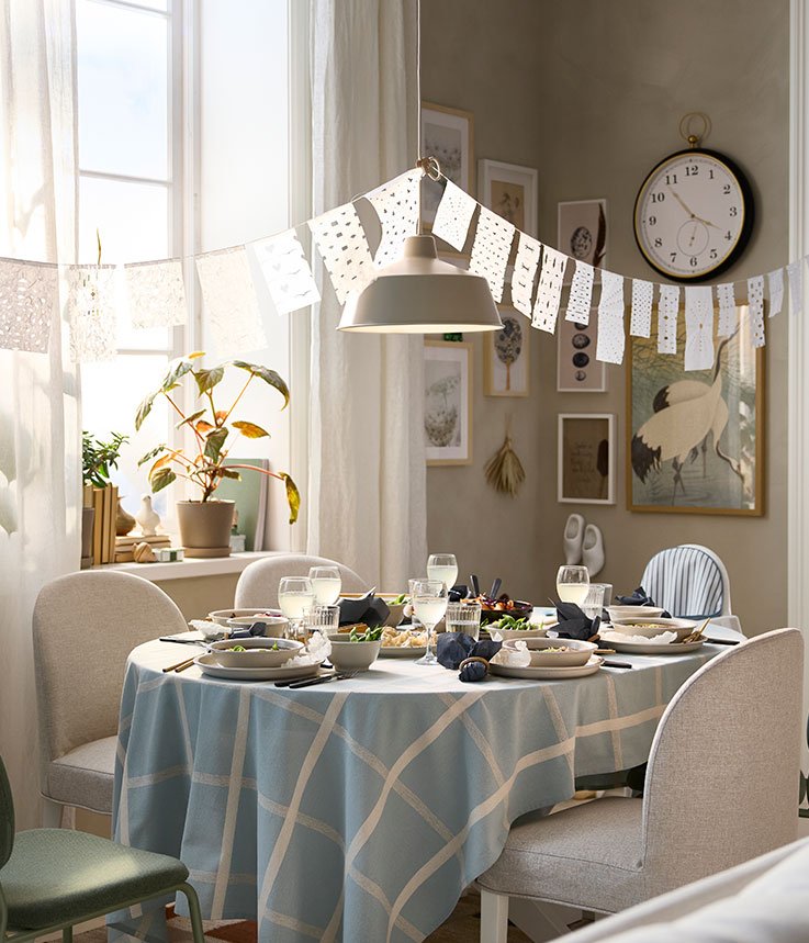 El luminoso comedor cuenta con una mesa extensible ROSENTORP que se ha desplegado para dar cabida a cinco sillas y una trona.