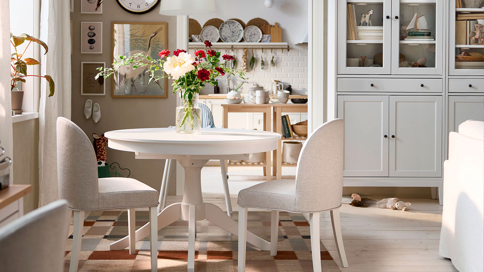 El luminoso comedor cuenta con una mesa extensible ROSENTORP blanca,  dos sillas ROSENTORP y una trona ANTILOP con bandeja.
