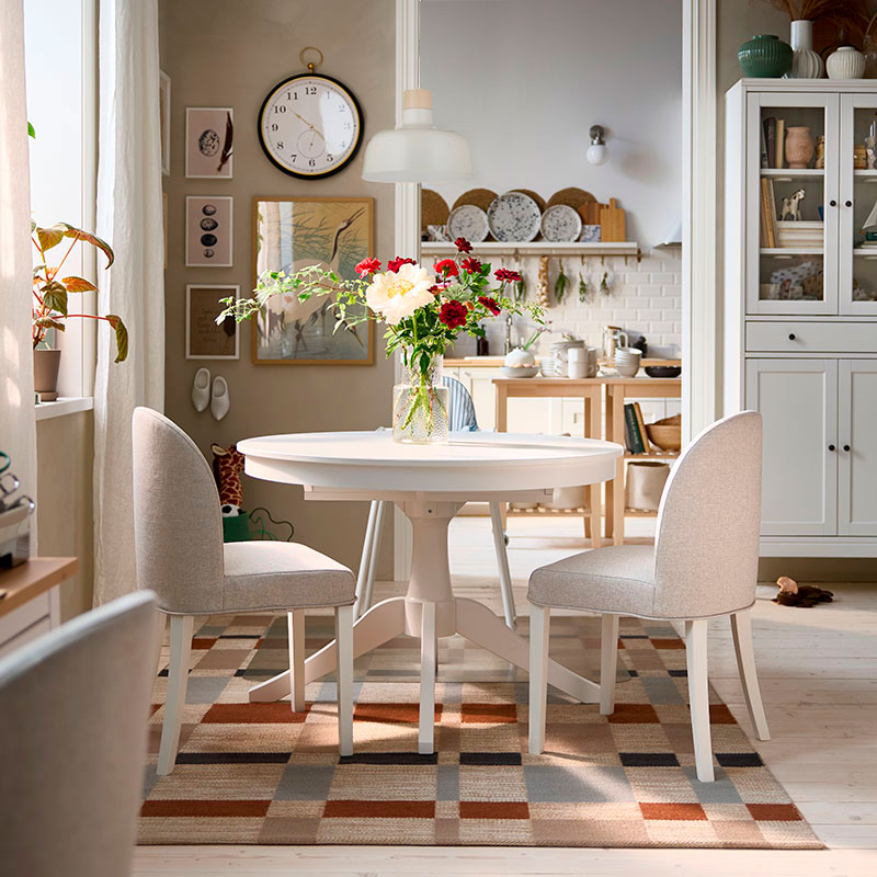 El luminoso comedor cuenta con una mesa extensible ROSENTORP blanca,  dos sillas ROSENTORP y una trona ANTILOP con bandeja.