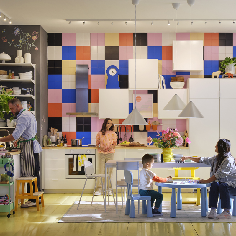Bright and colorful family-style kitchen, with people cooking, playing, and enjoying time together in a cozy and functional space.