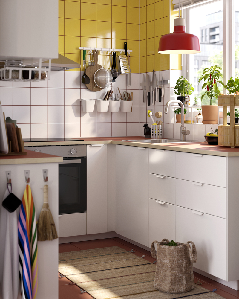Bright, compact kitchen with white cabinets, yellow tiles, and functional details—perfect for small, well-organized spaces.