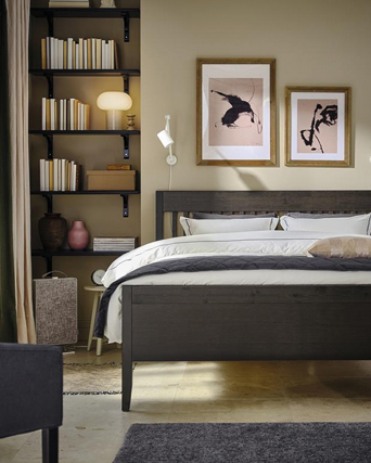Cozy bedroom with dark wood bed, built-in bookshelf, and modern artwork.