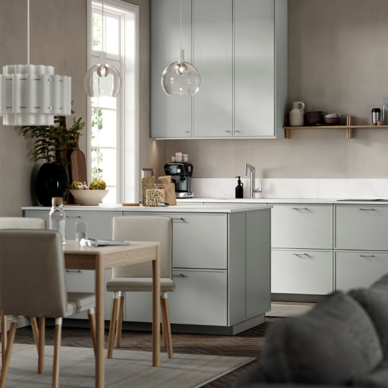 A modern kitchen featuring light-grey ASPUDDEN kitchen fronts, dark beige walls, wooden floors, and a white kitchen worktop.