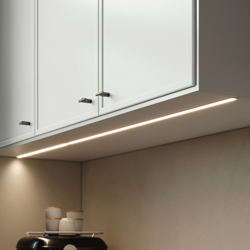 ASPUDDEN cover panel for lighting mounted under light grey cabinets, brightening the kitchen wall.