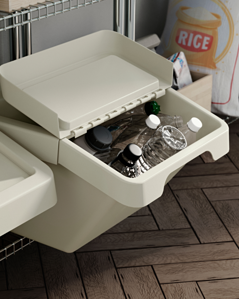 A SORTERA waste sorting bin with lid, partly open and used for recycling plastic bottles in a kitchen pantry.