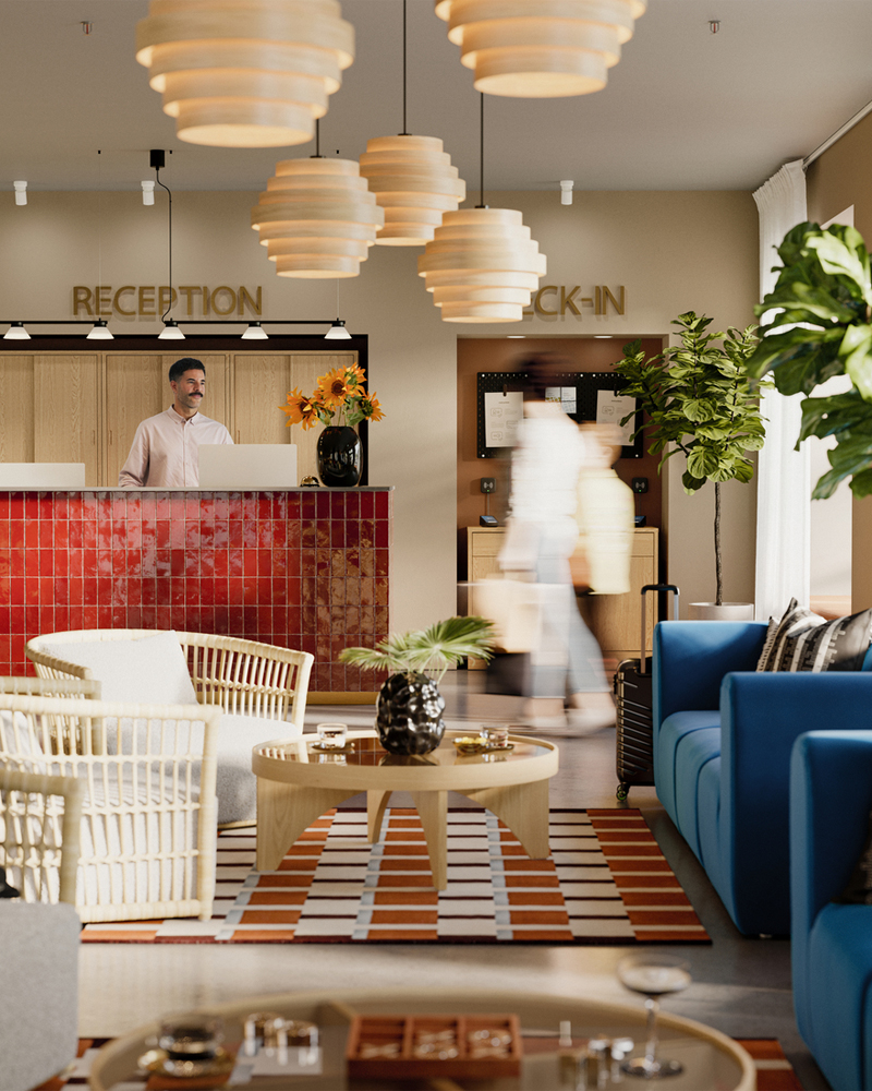 Escena en el vestíbulo de un hotel con un sillón de ratán STOCKHOLM 2025 gris/blanco, un sofá, una mesa de centro y dos personas sentadas conversando.