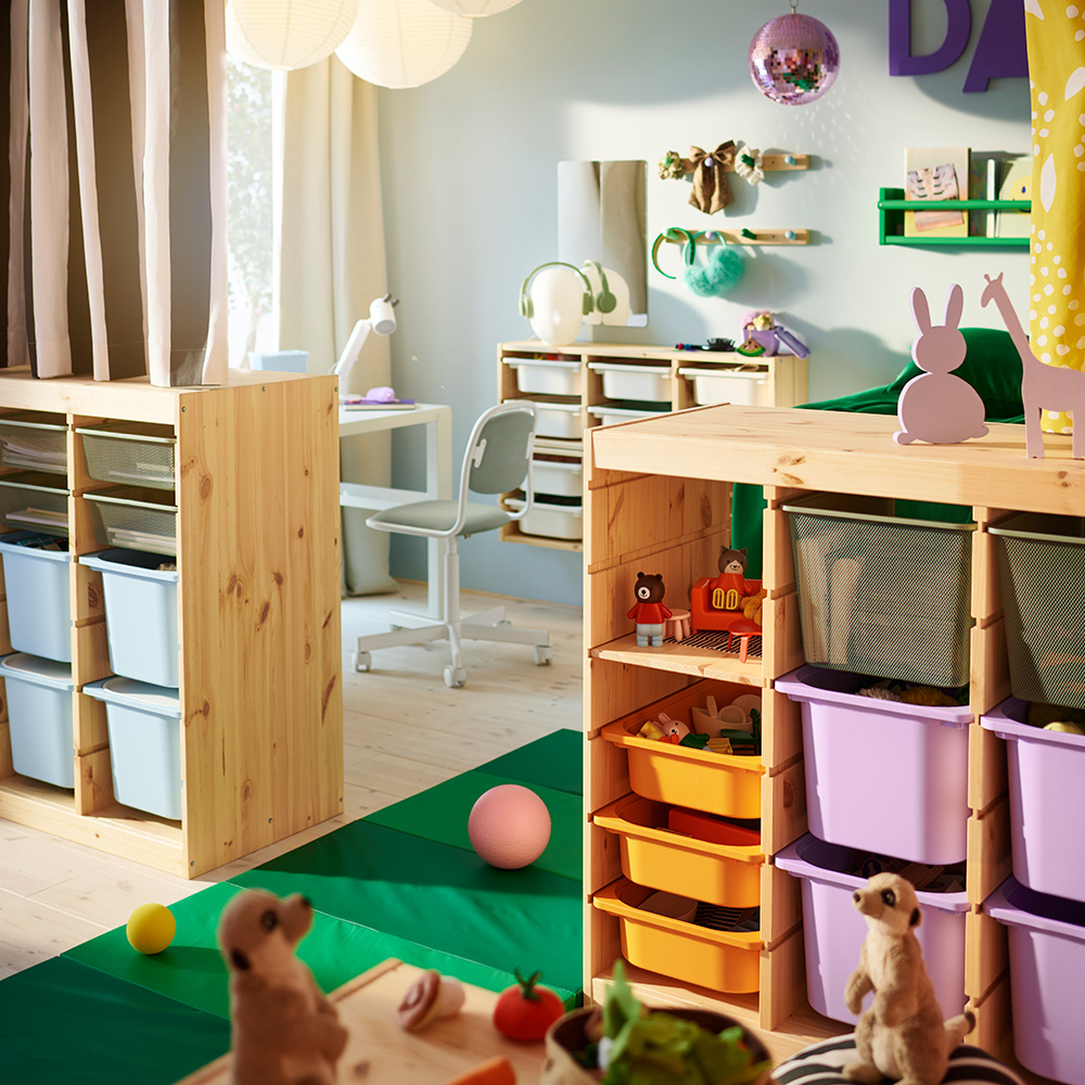 Two TROFAST room dividers in the middle of a shared children’s room with a different curtain pulled across the top of each.
